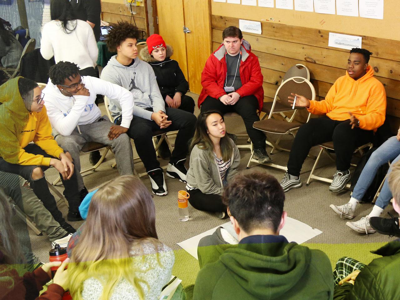 Des jeunes discutant en groupe lors d’une conférence.